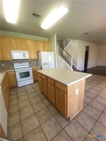 a kitchen with a cabinets and white appliances