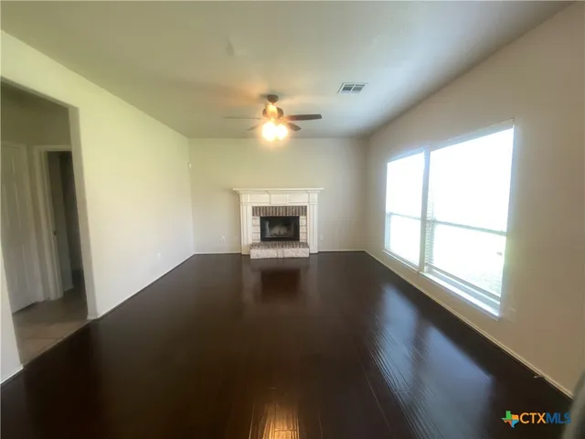 an empty room with windows and fireplace