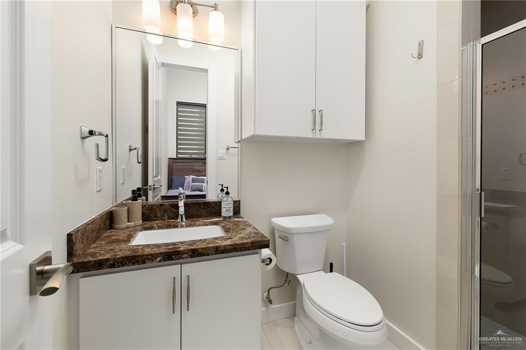 4401 South L Street McAllen, TX 78503 - Photo 18 of 20 a bathroom with a granite countertop toilet sink and mirror