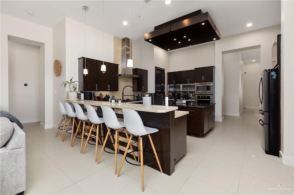 4401 South L Street McAllen, TX 78503 - Photo 6 of 20 a kitchen with stainless steel appliances kitchen island granite countertop a sink and a refrigerator