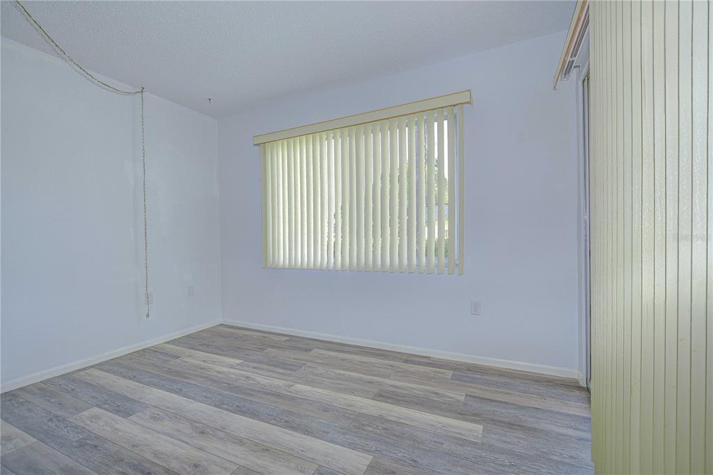 11511 113th Street, Unit 33D Largo, FL 33778 - Photo 14 of 33 a view of an empty room with wooden floor and a window