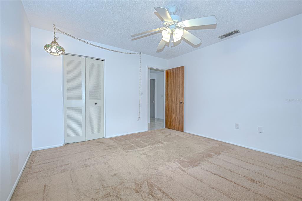 11511 113th Street, Unit 33D Largo, FL 33778 - Photo 21 of 33 a view of a big room with chandelier fan and closet