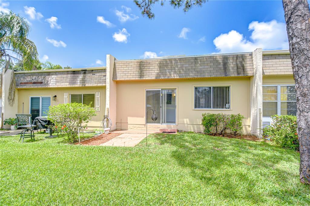 11511 113th Street, Unit 33D Largo, FL 33778 - Photo 26 of 33 a front view of a house with a yard and outdoor seating