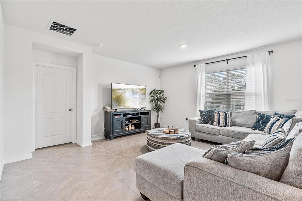 511 Baroness Way DeLand, FL 32724 - Photo 15 of 37 a living room with furniture a large window and a flat screen tv