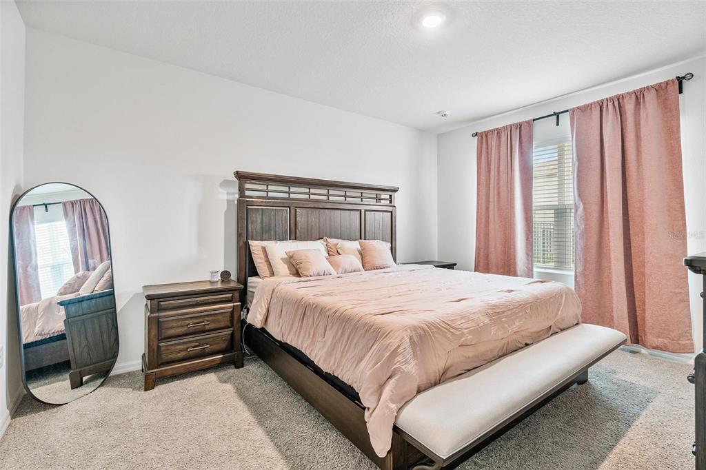 511 Baroness Way DeLand, FL 32724 - Photo 16 of 37 a bedroom with a bed a rug and wooden floor