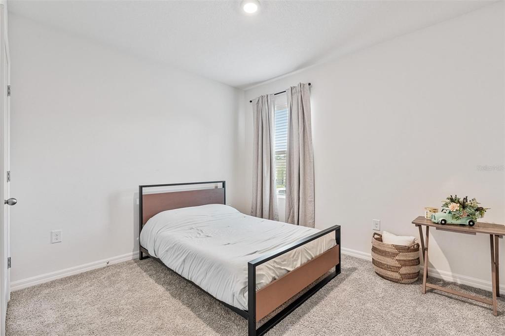 511 Baroness Way DeLand, FL 32724 - Photo 24 of 37 a bedroom with a bed and a potted plant