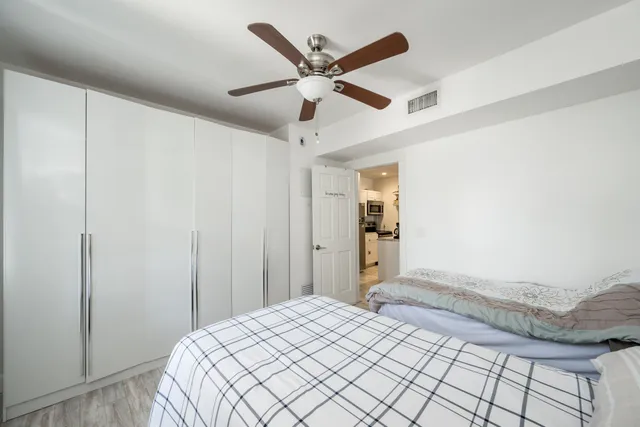a bedroom with a bed and a ceiling fan