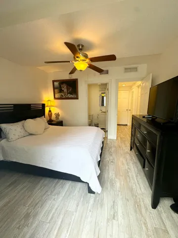 a bedroom with a bed and a flat tv screen on a dresser