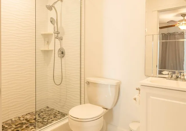 a bathroom with a granite countertop toilet sink and shower