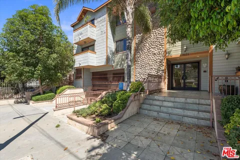 a front view of a house with potted plants