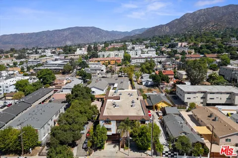 an aerial view of residential houses with outdoor space and trees