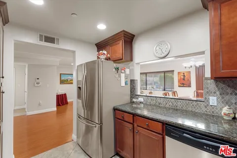 a kitchen with stainless steel appliances granite countertop a refrigerator and a sink