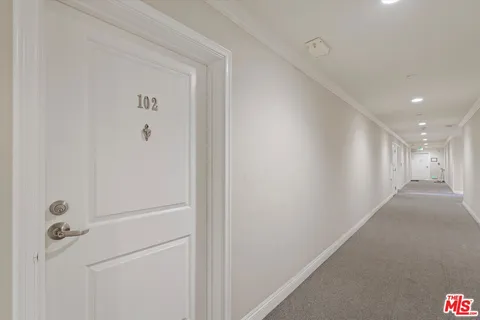 a view of a hallway with wooden floor windows and a living room