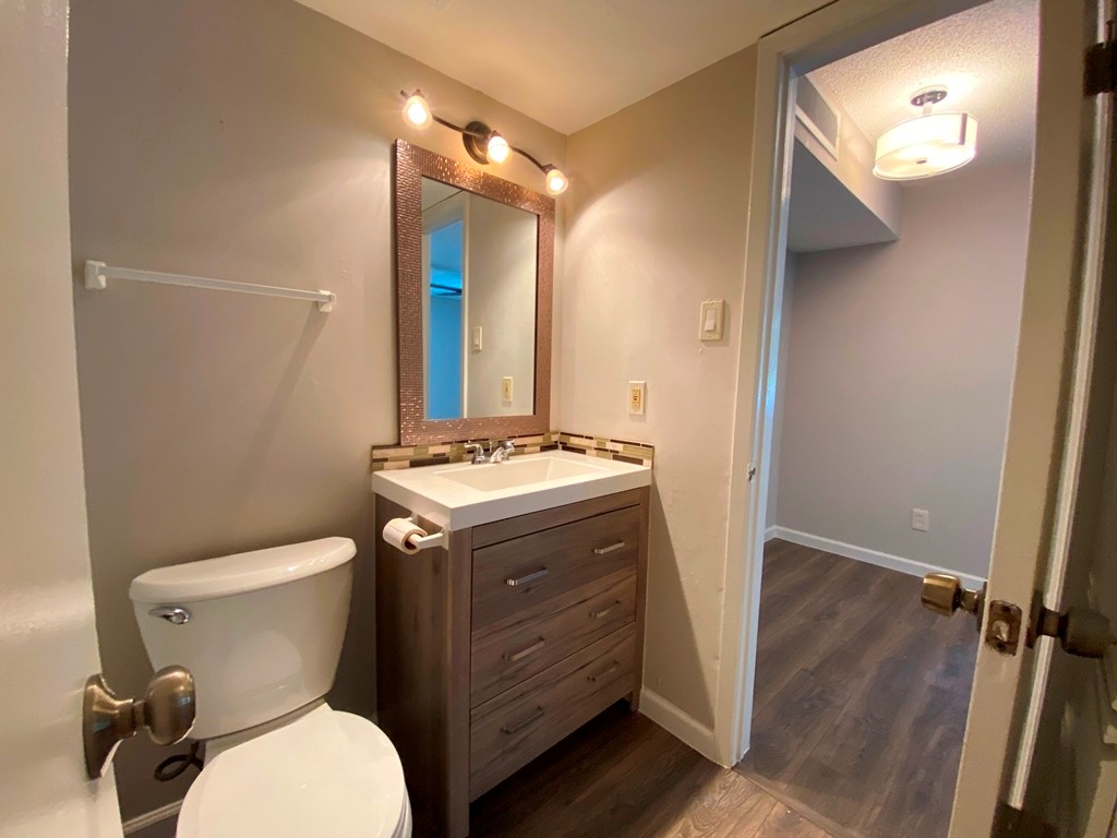 1840 Burton Drive, Unit 128 Austin, TX 78741 - Photo 12 of 22 a bathroom with a granite countertop toilet sink and mirror