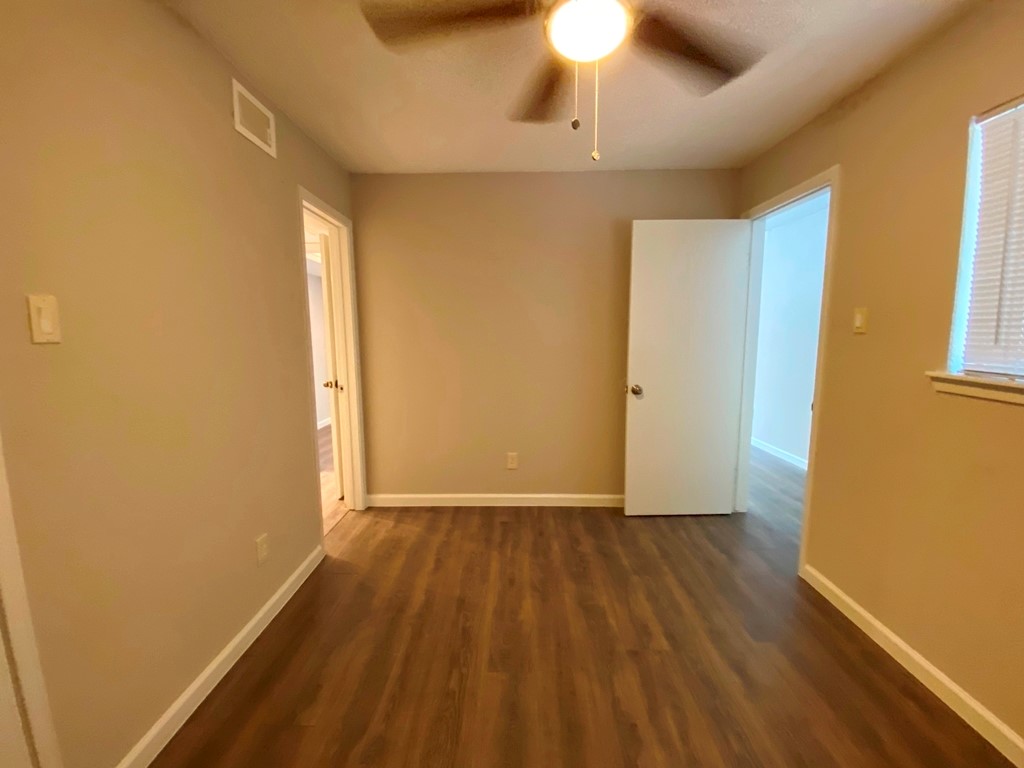 1840 Burton Drive, Unit 128 Austin, TX 78741 - Photo 16 of 22 wooden floor in an empty room with a window