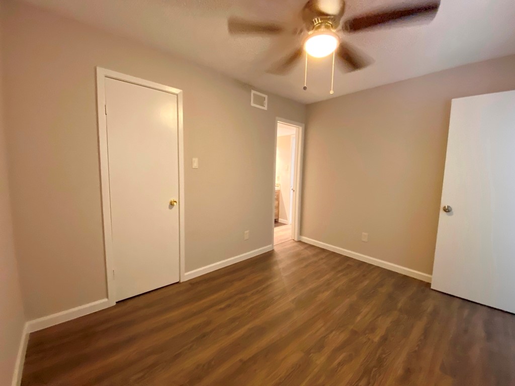 1840 Burton Drive, Unit 128 Austin, TX 78741 - Photo 17 of 22 wooden floor in an empty room with a window