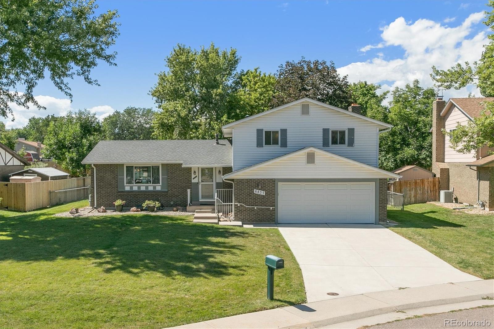 6837 Vivian Street Arvada, CO 80004 - Photo 1 of 28 a front view of a house with garden