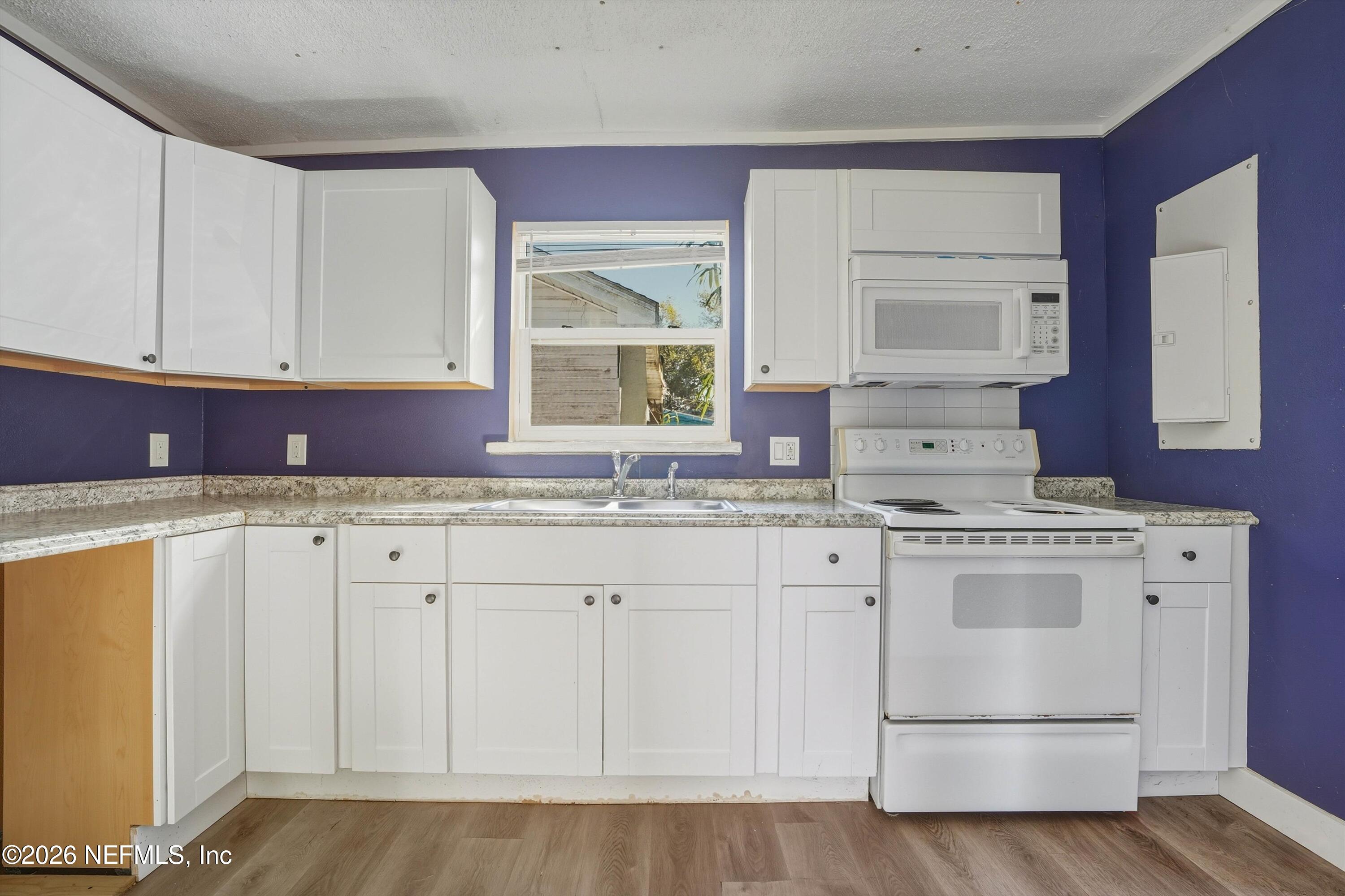 27 Julia Street St. Augustine, FL 32084 - Photo 34 of 46 a kitchen with granite countertop white cabinets and a sink