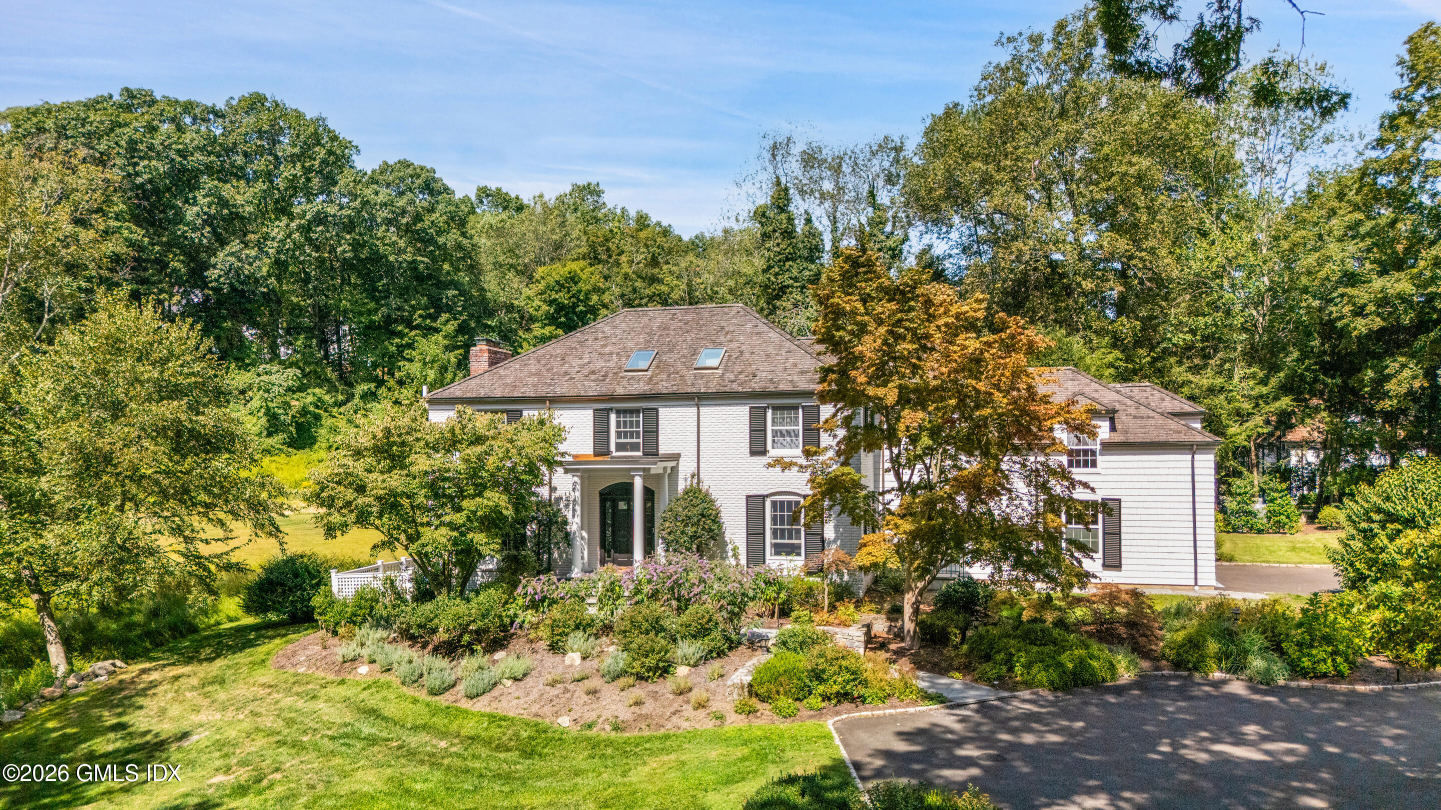 118 Butternut Hollow Road Greenwich, CT 06830 - Photo 2 of 44 a front view of a house with a yard and fountain