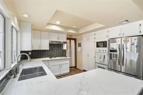 a kitchen with stainless steel appliances a sink a stove a refrigerator cabinets and a counter top space