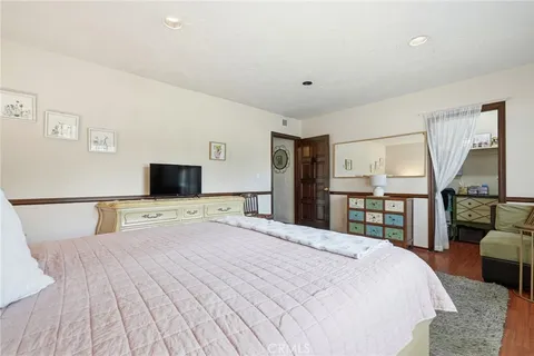 a bedroom with a large bed and a flat screen tv