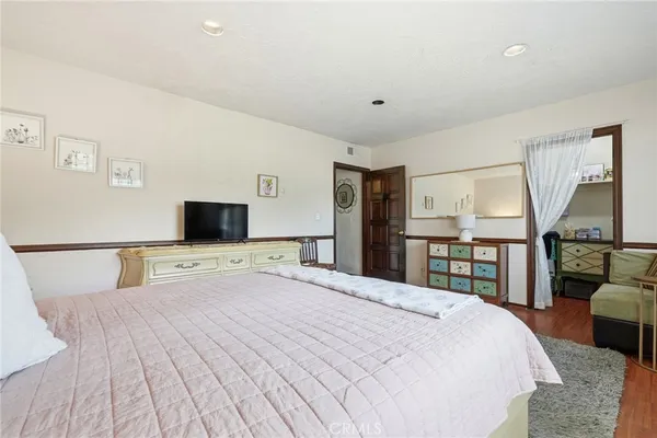a bedroom with a large bed and a flat screen tv