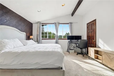 a bedroom with a bed and large windows