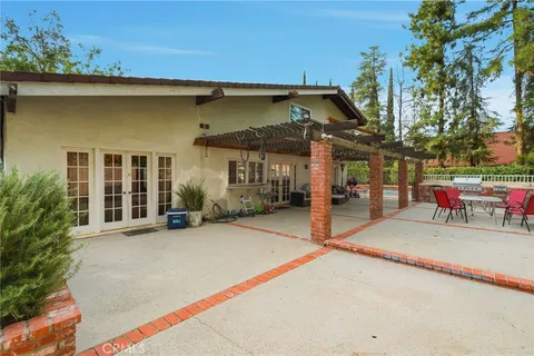 a view of a house with a patio and a yard