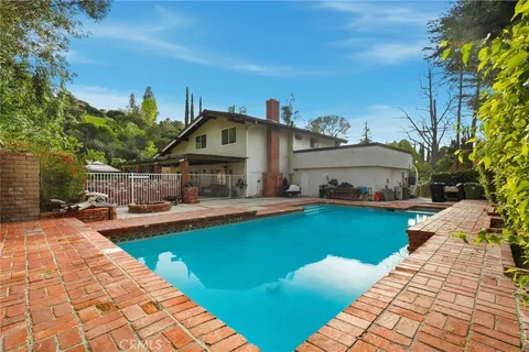 a front view of a house with swimming pool garden and patio
