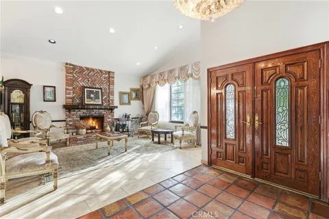 a living room with furniture a large window and potted plants