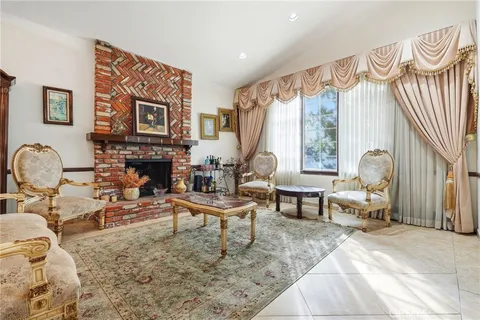 a living room with furniture fireplace and a large window