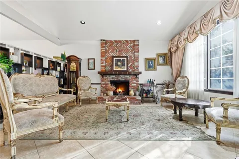 a living room with furniture a fireplace and a large window
