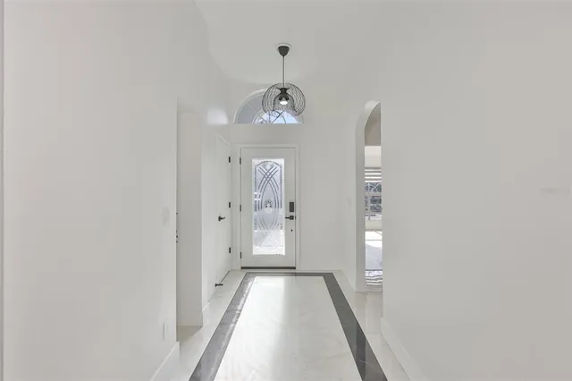 a view of a hallway with wooden floor and a living room