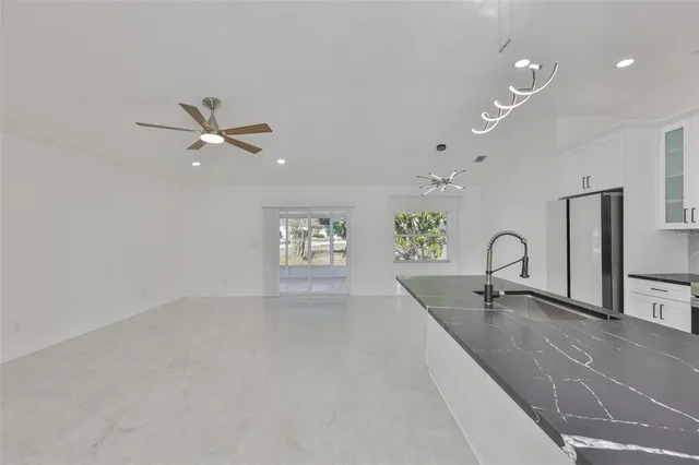 a kitchen with a sink stainless steel appliances cabinets and a window