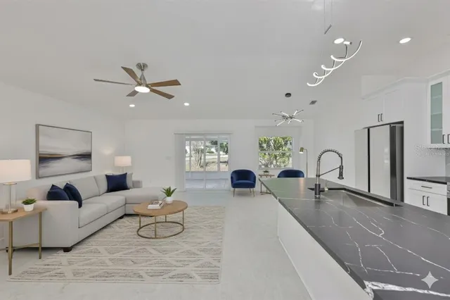 a large white kitchen with kitchen island a sink stainless steel appliances and cabinets