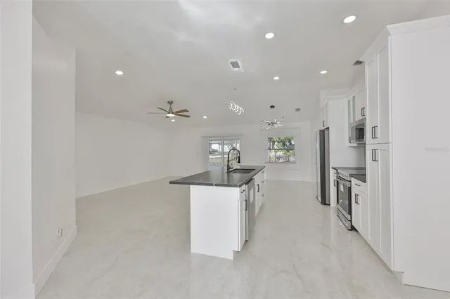 a large kitchen with a large counter top appliances and cabinets