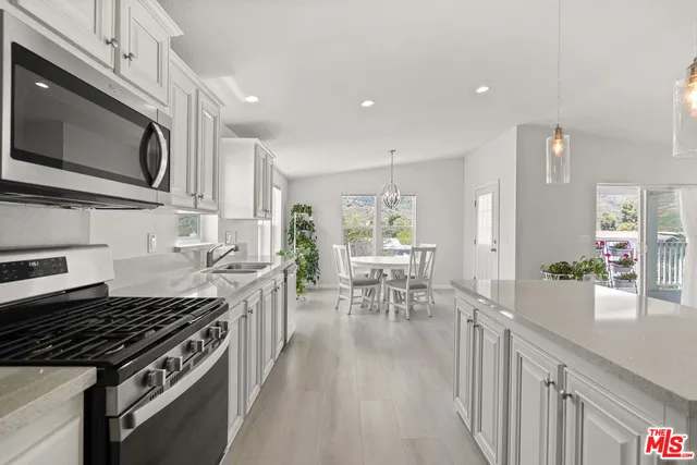 a kitchen with stainless steel appliances kitchen island granite countertop a stove a sink and a microwave