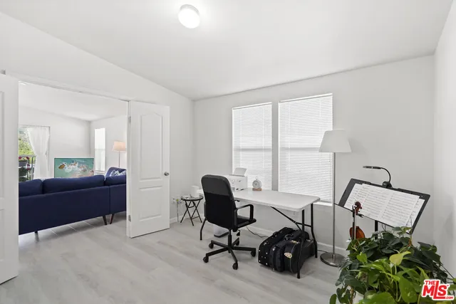 a view of a workspace with furniture and a window