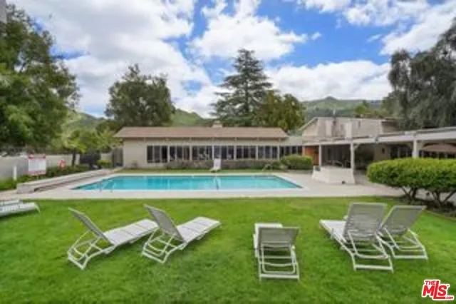 a view of a house with swimming pool and sitting area