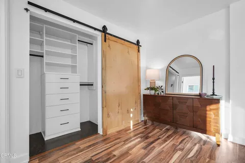 a bedroom with a bed and wooden floor