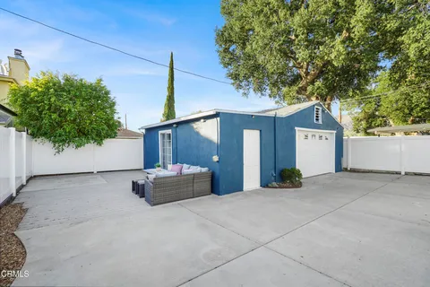 a view of a white house with a large tree and a yard