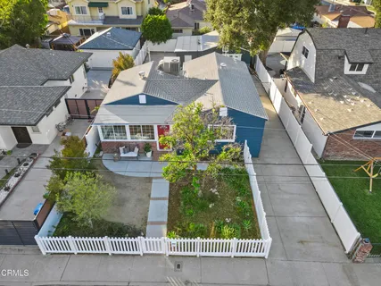 an aerial view of residential houses with outdoor space and trees