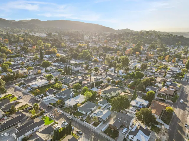 an aerial view of residential houses with outdoor space and trees