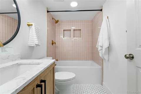 a bathroom with a sink a toilet and shower