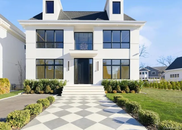 a front view of a house with a yard and potted plants