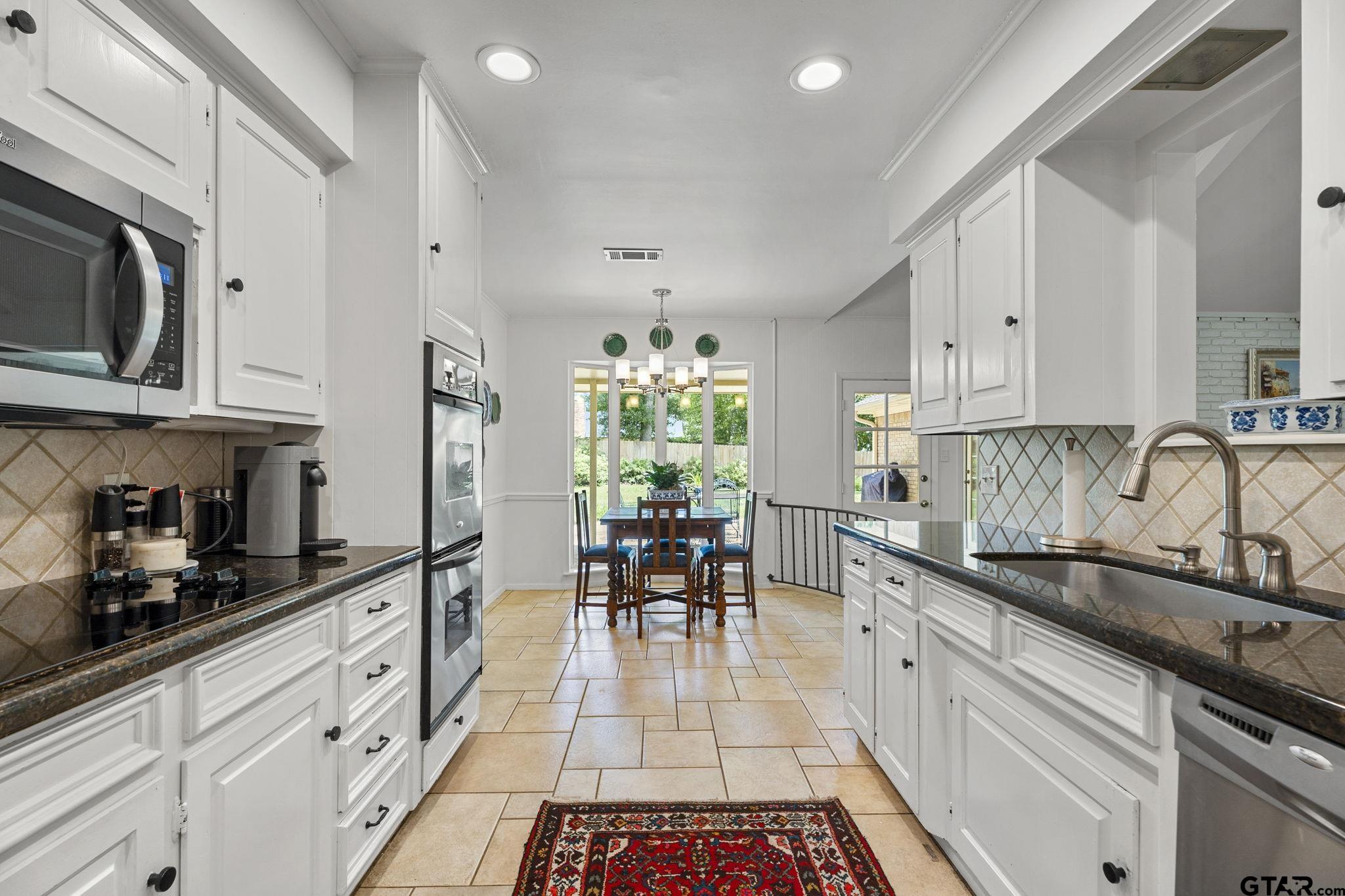 3608 Pollard Drive Tyler, TX 75701 - Photo 6 of 14 a kitchen with granite countertop a sink a stove and cabinets