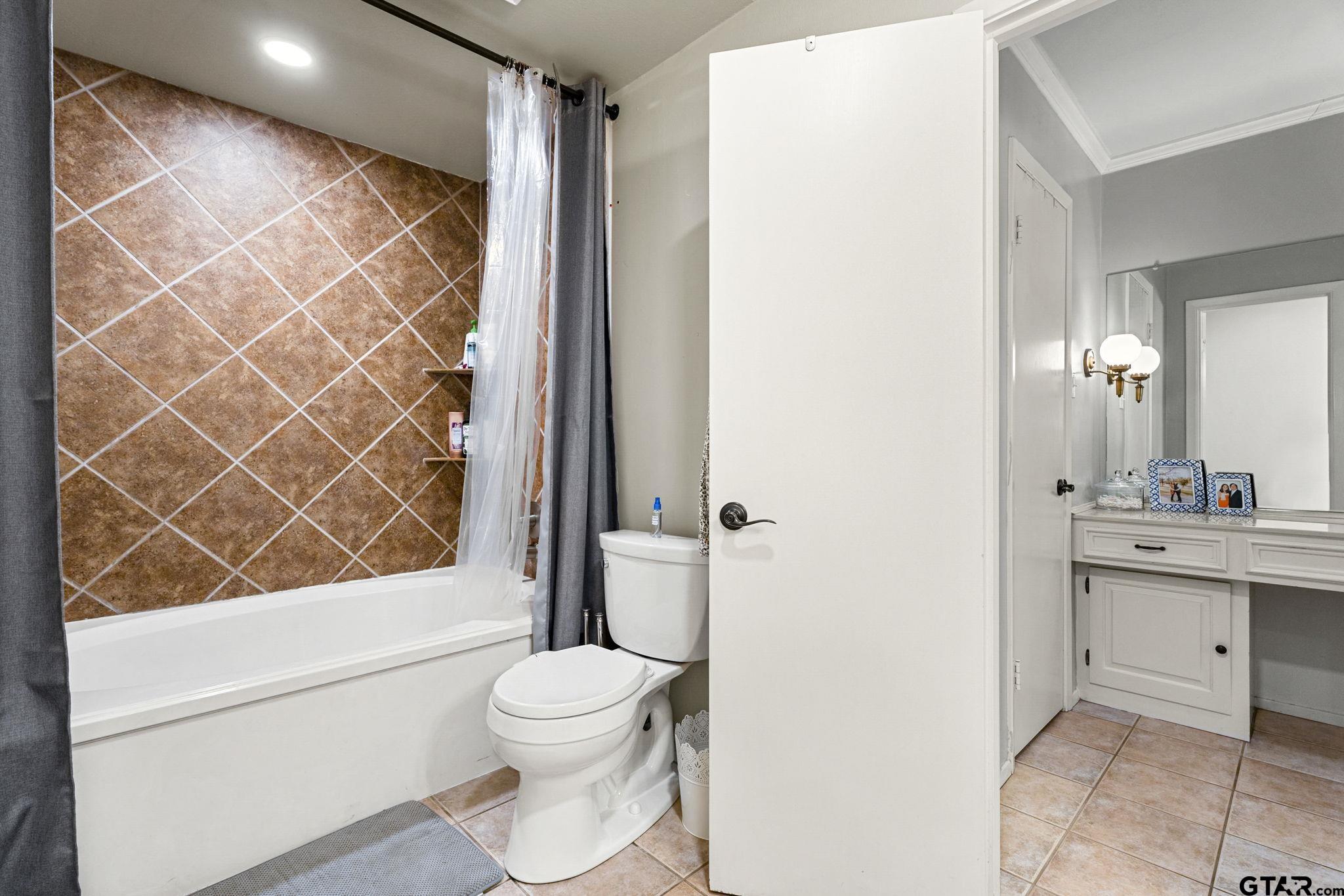 3608 Pollard Drive Tyler, TX 75701 - Photo 8 of 14 a bathroom with a toilet a sink and a bathtub
