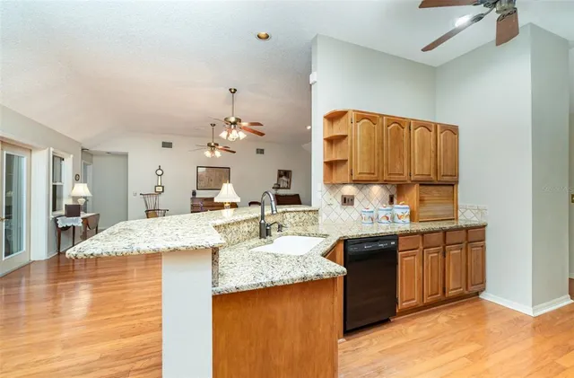 a kitchen with stainless steel appliances granite countertop a refrigerator and a stove top oven
