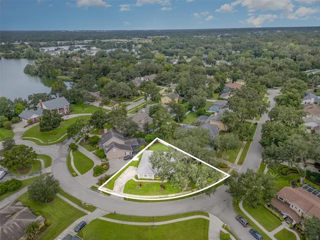 an aerial view of residential houses with outdoor space and trees