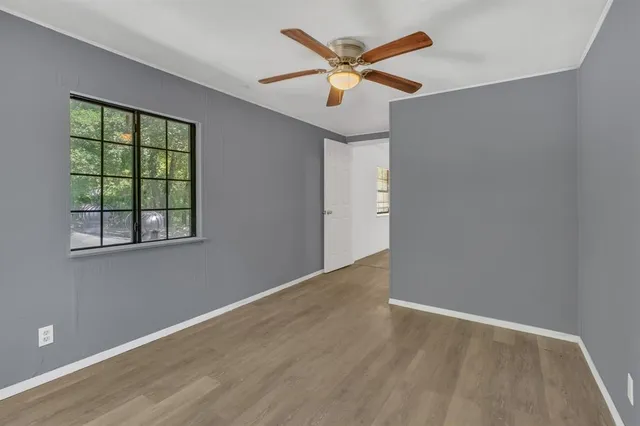 an empty room with a window and a ceiling fan